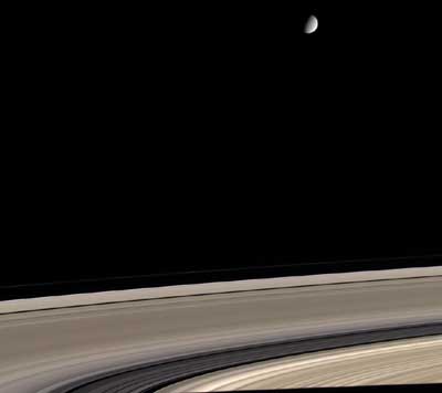 הירח השבתאי הקרחי אנסלדוס מעל הטבעות. צילום נאס