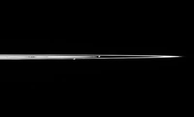 From the side of Saturn's rings you can see the two shepherd moons of the rings: Pandora (right) and Prometheus (left).