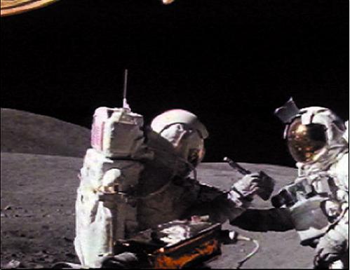 The Lunar Rover cine camera captures Apollo 16 Commander John Young dusting Charlie Duke's camera