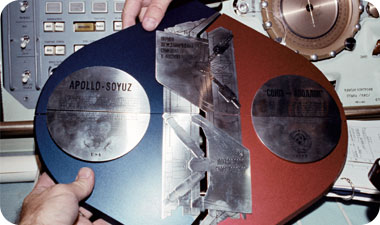 تم تجميع هذه اللوحة التذكارية من قبل رواد فضاء من الاتحاد السوفيتي ورواد فضاء من الولايات المتحدة أثناء وجودهم في الفضاء، خلال مهمة أبولو-سويوز في 24.7.1975/XNUMX/XNUMX