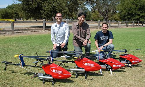 Andrew Ng, professor of computer science (center) and his research students Peter Abel (left) and Adam Coates (right) developed an artificial intelligence system that allows the helicopters pictured to perform complicated aerial stunts on their own. The autonomous helicopters teach themselves to fly by watching the maneuvers of helicopters controlled by remote control by a human pilot.