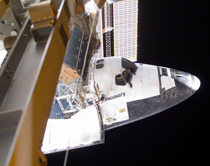 דיסקברי עוגנת בתחנת החלל מזוית יוצאת דופן - בעת הליכת חלל בידי אחד האסטרונאוטים