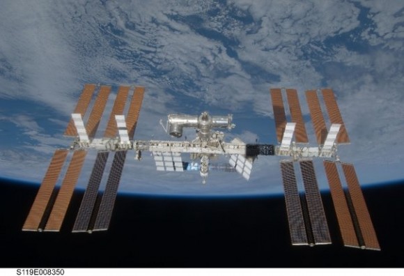 תחנת החלל הבינלאומית כפי שצולמה מהחללית דיסקברי ביום רביעי השבוע לקראת עזיבתה את התחנה לנחיתה הצפויה בשבת. לראשונה כוללת התחנה את הסדרה המלאה של קולטי השמש המיועדים לאספקת החשמל