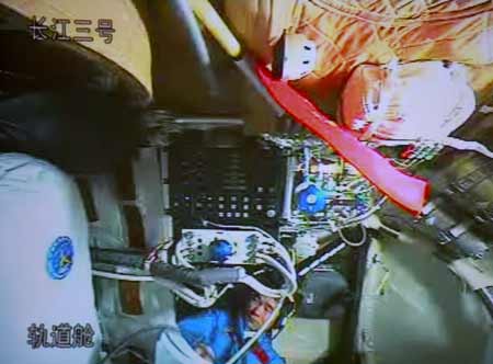 Technaut Liu Boming unfurls the spacesuit that his friend Zhai Zhigang will wear this morning for the first Chinese spacewalk. Photo: Shinoa