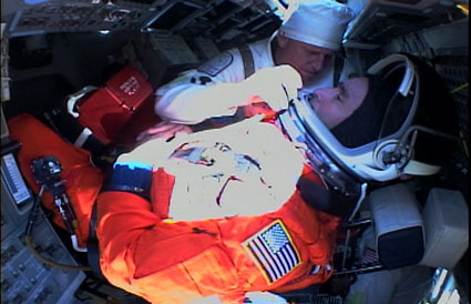 אנשי צוות STS-119 מתארגנים במקומותיהם בסיוע צוות הקרקע שעות אחדות לפני השיגור. צילום: הטלוויזיה של נאס''א (NASA TV)
