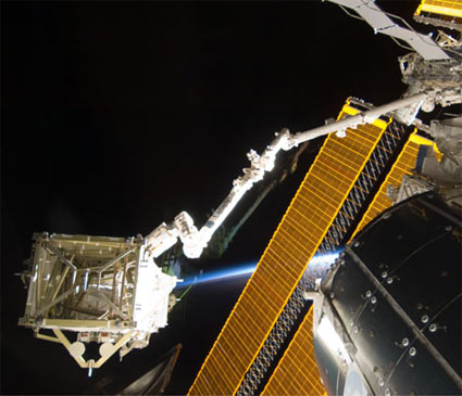 רכיב S6 בצד שמאל למטה, עושה דרכו למקומו באמצעות הזרוע הרובוטית של תחנת החלל עם תחילת הליכת החלל היום