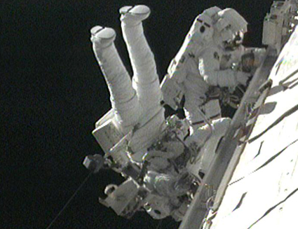 Robert Satcher and Randy Breznik work outside the space station on the third spacewalk of mission STS-129