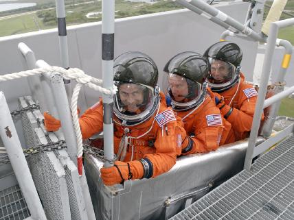 שלושה אסטרונאוטים מצוות משימה STS-127 - משמאל: תום מאשבורן, טים קורפה ודייב וולף מתאמנים בנטישת מעבורת החלל במקרה של תקלה ביום השיגור. מדובר בתרגיל שגרתי המתבצע לפני כל משימת מעבורת. צילום: נאס''א