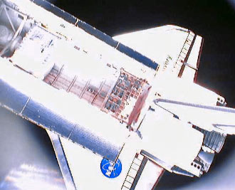המעבורת דיסקברי כפי שצולמה מתוך לווין זעיר ששחררו אנשי הצוות שלה מתוך סיפון המטען ב-20 בדצמבר 2006.