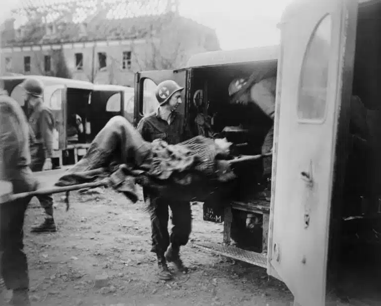 American soldiers evacuate survivors of a liberated concentration camp, some in ambulances. Photo: shutterstock