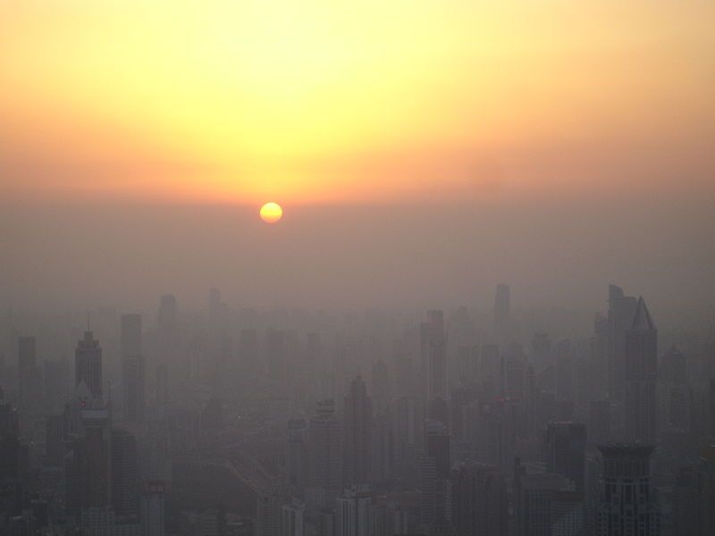 The sun sets above the smog line in Shanghai, China. From Wikipedia