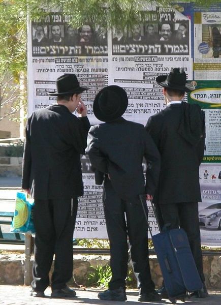 Young ultra-Orthodox in typical clothing read a poster against the support of the "Torah Judaism" party in the Sharon government during the disengagement. From Wikipedia