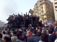 מפגינים מטפסים על רכב צבאי בכיכר תחריר, קהיר, במהפכת ינואר-פברואר 2011. צילום: רמי ראוף, מתוך WIKIMEDIA COMMONS