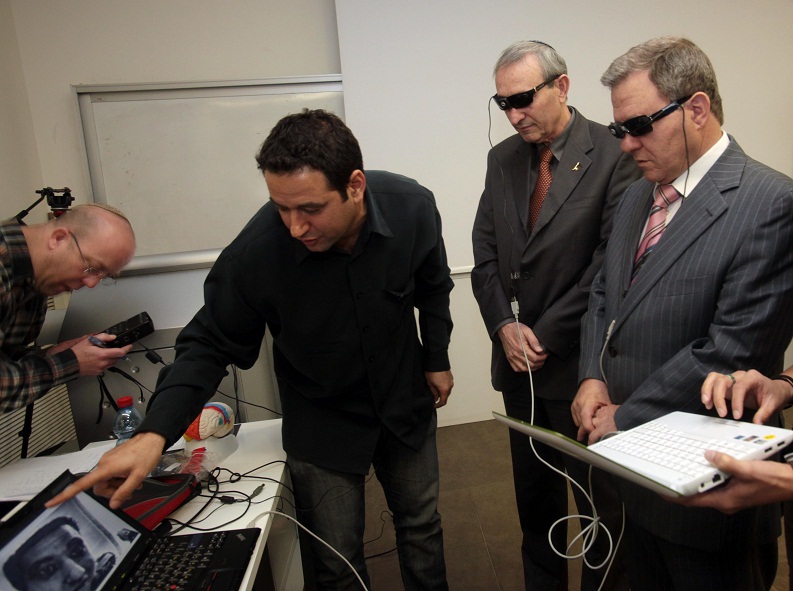In the attached photo, the chairman of the science committee MK Meir Shtrit and the president of the Hebrew University Prof. Menachem Ben-Shashon experiment with a new development by Dr. Amir Amadi from the Edmond and Lili Safra Center for Neuroscience (left) of binoculars that allow the blind to see shapes by translating them into sounds. (Photo: Anat/ Sashon Thiram)