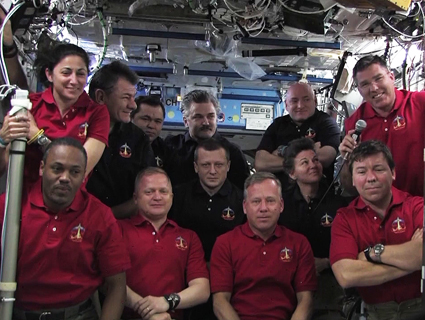 בתמונה: כל 12 אנשי הצוות - ששה מתנחת החלל וששת האסטרונאוטים של דיסקברי התכנסו למסיבת עיתונאים בשידור חי
