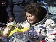 קיידי קולמן מקבלת פרחים לאחר הנחיתה בקזחסטן. צילום: NASA TV