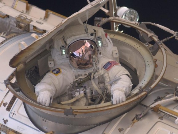 האסטרונאוט דרו פיוסטל מציץ ממינעל האוויר של תחנת החלל הבינלאומית בהליכת החלל שהתקיימה ביום ראשון, 22 במאי 2011