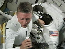 Astronaut Mike Possum performs a rehearsal in a space suit in the Quest space shoe. Photo: NASA TV