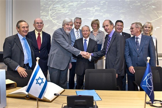 Director General of Capt. Ralph Hoyer, the Israeli ambassador to the UN institutions in Geneva, Dr. Aharon Leshanu-Yer, and the president of the CERN Council, Michael Spiro, shake hands at the signing ceremony yesterday. PR photo: CERN