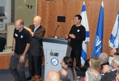 נשיא המדינה שמעון פרס חותם על דף הייסוד של פרויקט החללית הישראלית לירח, על גבו של איש ההייטק אראל מרגלית. על הבמה גם יריב בש, ממייסדי SPACE-IL