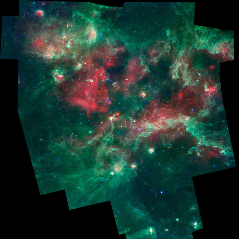 An infrared image of the Cygnus X star-forming region colored with wavelength-coded artificial colors. Light at 3.6 microns is colored blue, light at 4.5 microns in blue-green, 8 microns in green and 24 microns in red. These images were taken before the Spitzer mission ran out of cooling gas in 2009, becoming a "hot" mission.