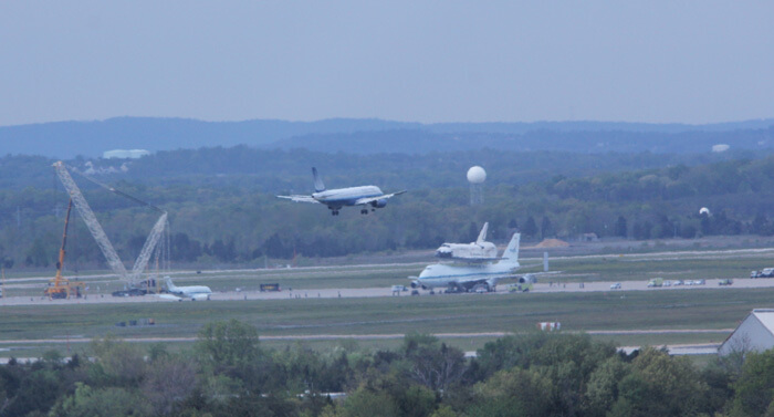 מטוסי נוסעים נוחתים ונוסעיהם הצליחו לצפות במעבורת דיסקברי על גבי מטוס התעבורה נאס"א 905. צילום: קן קריימר, יוניברס טודיי