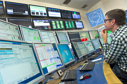 פיסיקאי מנטר את קרן ה-LHC ממרכז הבקרה של סרן. צילוםך CERN, מתוך הרצה בשנת 2011