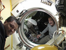 מפקד צוות 31 של תחנת החלל אולג קונוננקו (משמאל) ומפקד צוות 30 דן בורבאנק מתכוננים לסגירת הדלתות בין תחנת החלל לבין החללית סויוז TMA-22. צילום: נאס"א