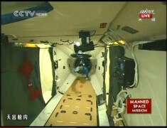 מפקד החללית שנז'ו 9 ג'ינג הייפנג נכנס לתוך מעבדת החלל טיאנגונג 1. צילום: הטלוויזיה הסינית