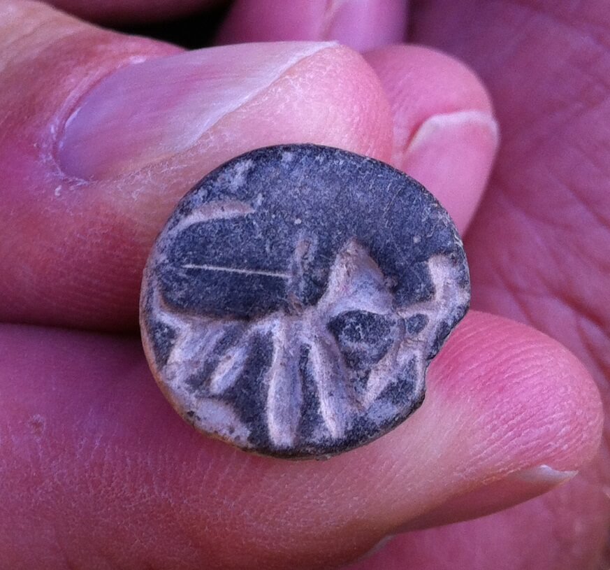 "A stone seal from Tel Beit Shemesh engraved with the figure of a large animal (a lion?) and the figure of a man raising his hand to its head." Credit: Raz Lederman