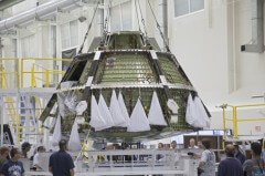 עגורן מרים את מודול הצוות אוריון EFT-1 ממתקן האיחסון שלו להעברה להמשך ההרכבה במתקן הבדיקות והתפעול במרכז החלל קנדי של נאס"א בפלורידה Credit: NASA/Frankie Martin