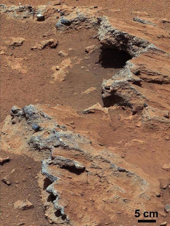 איזור במאדים בו זרמו מים. בתחתית התמונה הסלע הוטה הנראה כמו מדרכה שבורה - עדות לזרימת מים במקום