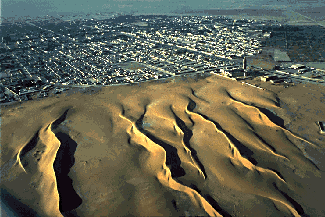 דיונות חול בצורת סהר מאיימות על העיר נאוקהצ'וט בירת מאוריטניה בשנת 2002. צילום לוויין: נאס"א