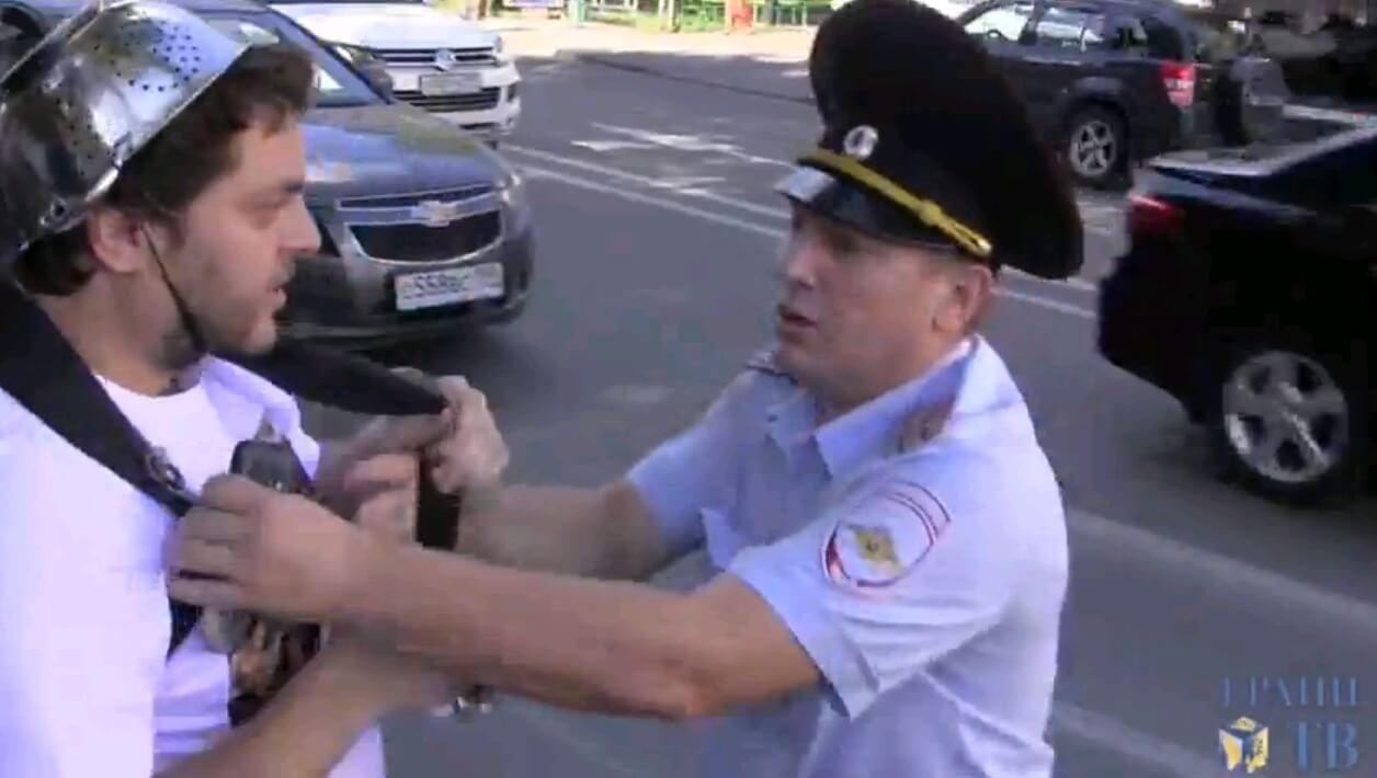 שוטר רוסי מתעמת עם מפגין של כנסיית "מפלצת הספגטי המעופפת" במוסקווה, 17 באוגוסט 2013. מתוך YOUTUBE