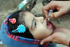 ילדה בפשוואר, פקיסטן, מקבלת חיסון פוליו מוחלש בטיפות בשנת 2002. צילום: shutterstock