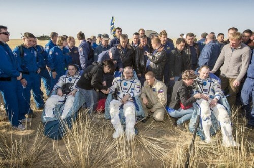 Photo: Members of the 36th crew are assisted by rescue personnel after landing in the Soyuz TMA-08M spacecraft. Photo: NASA