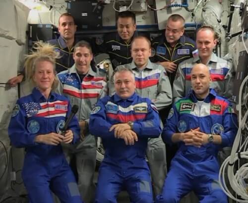   אסטרונאוטים מהצוותים 37,38 ו-39 במהלך מסיבת עיתונאים בתחנת החלל הבינלאומית. בשורה הקדמית, האמריקנית קארק נייברג, הרוסי פיודור יורצ'יכין והאיטלקי לוקה פרמיטאנו. בשורה השניה (גם כן משמאל לימין) האמריקני מייקל הופקינס, והרוסים אולג קטוטב וסרגי ריז'ינסקי. בשורה האחורית ריק מסרצ'ו האמריקני, קיוצ'י ואקאטה היפני והקסומונאוט הרוסי מיכאיל טיורינ. צילום מסך: NASA TV 