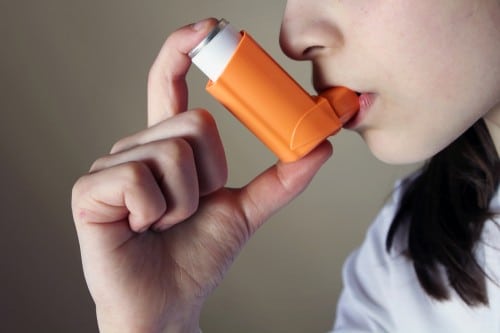 A girl takes asthma medicine in an inhaler. Photo: shutterstock