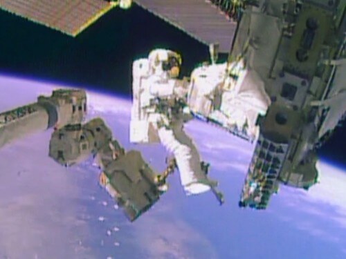 رائد الفضاء مايك هوبكنز يركب على الذراع الآلية لمحطة الفضاء الدولية حاملاً مضخة الأمونيا التي تزن 350 كجم عندما مرت المحطة فوق أمريكا الجنوبية.الصورة: تلفزيون ناسا