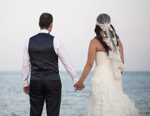 A newlywed couple watches the horizon. Photo: shutterstock