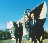 וילסון (משמאל) ופנזיאס (מימין) על רקע אנטנת השופר ששימשה אותם בעת גילוי קרינת הרקע הקוסמית. מקור: ויקיפדיה