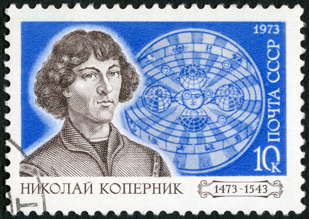 A stamp issued by the Soviet Union in 1973 on the occasion of the 500th anniversary of the birth of Nicolaus Copernicus, with the heliocentric universe model in the background. Photo: Olga Popova / Shutterstock.com