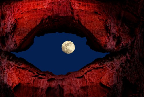 The moon peeks through an interesting rock on Earth. Photo: shutterstock