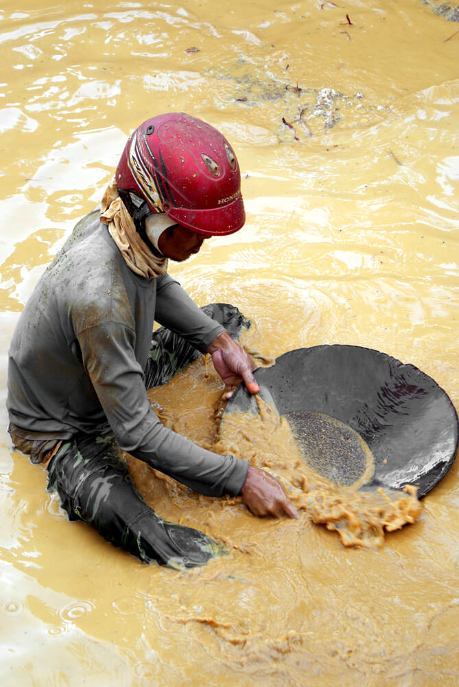 כורה מסנן זהב במכרה בתאילנד. צילום: Giambra / Shutterstock.com