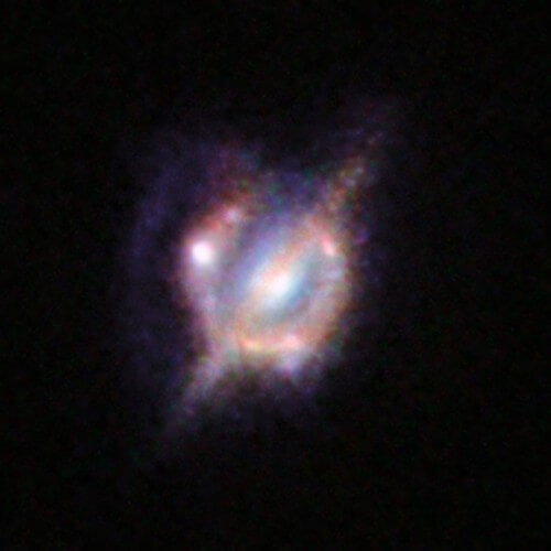 H-ATLAS J142935.3-002836  - עצם ביקום המרוחק המורכב משתי גלקסיות מתנגשות. צילום משולב: טלסקופ החלל האבל והטלסקופים הקרקעיים קק, אלמה והמערך הגדול מאוד