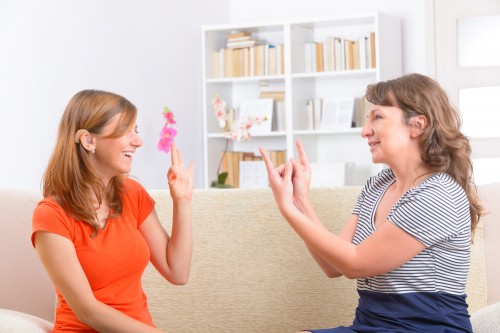 A deaf student speaks to her teacher in sign language. Photo: shutterstock