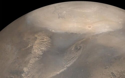 Early spring sandstorms at the Martian north pole. When the ice covering the pole begins to melt, temperature differences are created between the areas still covered with ice and the swirling winds. These clouds of dust are seen in a 2002 photograph taken by the Global Mars Surveyor spacecraft. The white polar ice cap consists of carbon dioxide in a frozen state. Photo: NASA/JPL/Malin Space Science Systems