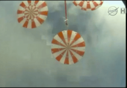 The Orion spacecraft photographs the parachutes above it, about a minute before landing in the Pacific Ocean. From NASA TV