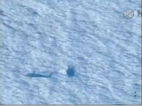 A helicopter passes over the Orion spacecraft after it landed in the Pacific Ocean, 5/12/14. Screenshot from NASA TV