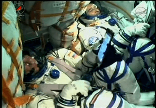 اثنان من رواد الفضاء الثلاثة في الطاقم رقم 43 لمحطة الفضاء الدولية بعد دقائق من الإقلاع من بايكونور، كازاخستان، 27 مارس 2014. لقطة شاشة من تلفزيون ناسا